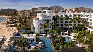 Un resort sul lungomare con spiaggia, piscina e vista sul mare e sulle montagne.