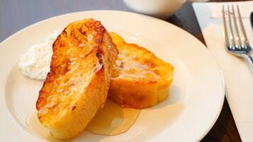 A plate with two pieces of toast and a dollop of cream on a white plate.