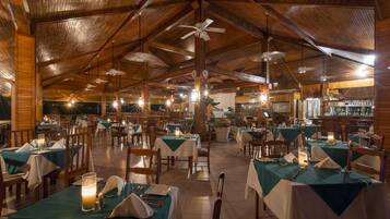 Un restaurante espacioso con altos techos de madera y varias mesas dispuestas para comer.