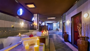 A spa area with a reception desk, candles, and a reception area with a red door. - Le Grand Courlan Spa Resort - Adults Only (Black Rock)