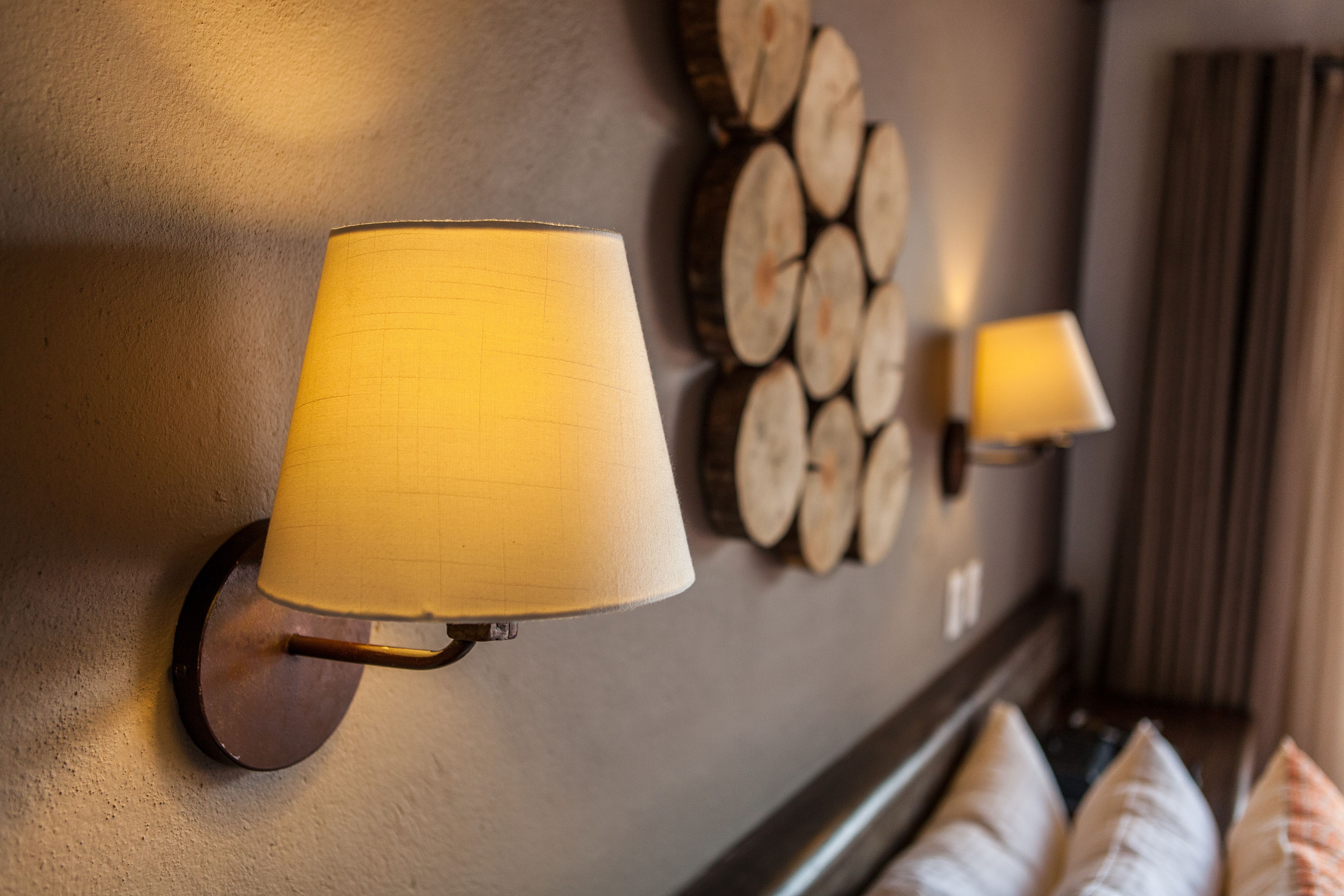 A wall-mounted lamp and a decorative log wall.