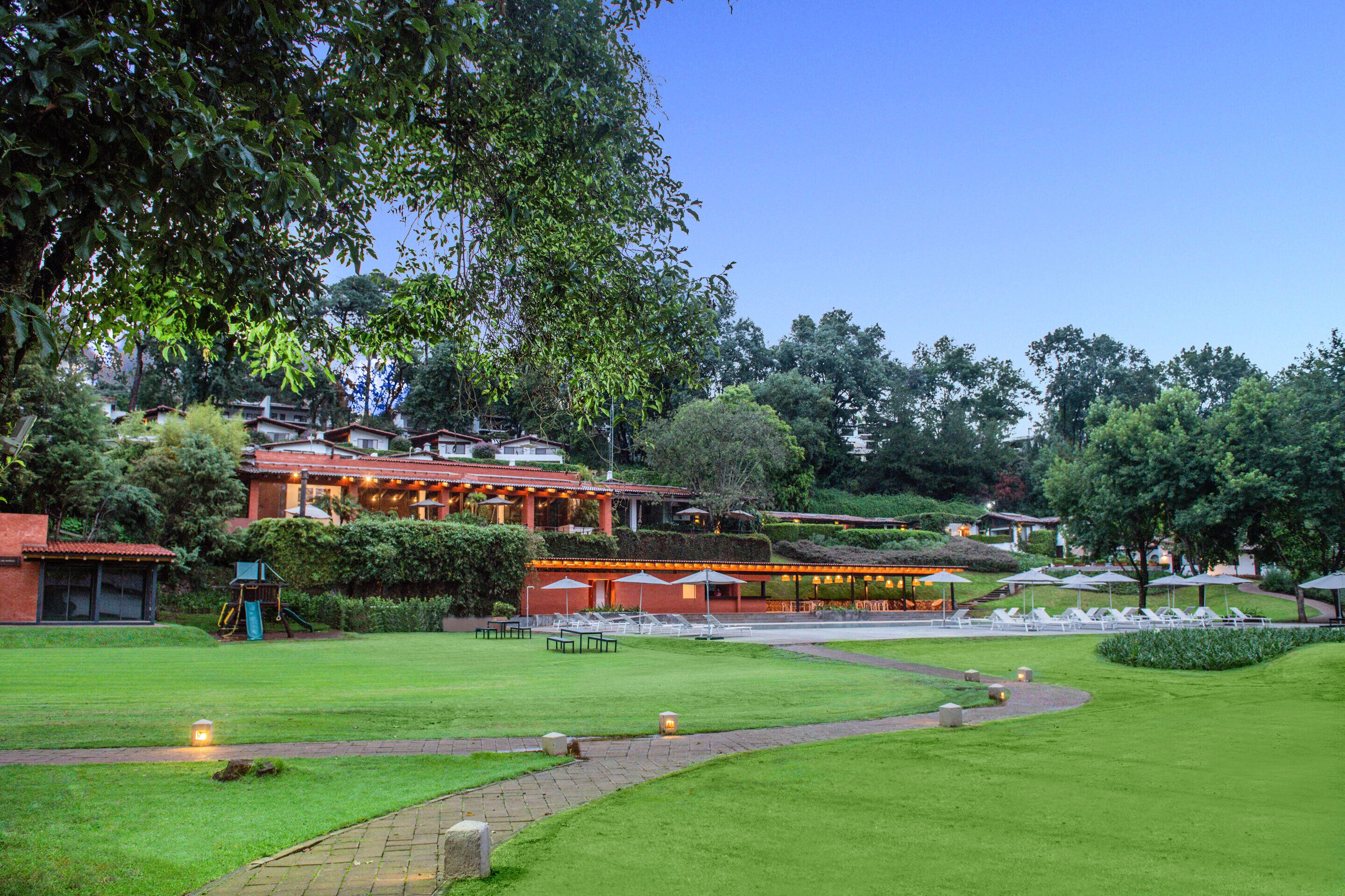 A hotel with outdoor seating, a well-maintained lawn, and a pathway.