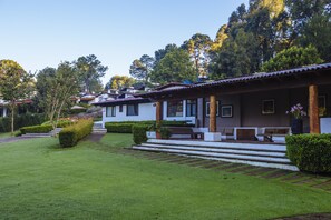 A row of white houses with brown roofs, surrounded by lush greenery and trees. - Hotel Avandaro Golf And Spa (Valle de Bravo)