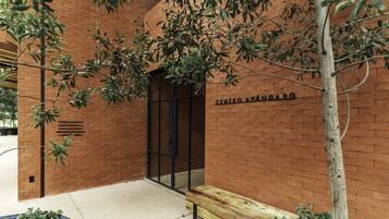 Un edificio de ladrillo con un banco de madera y una puerta.