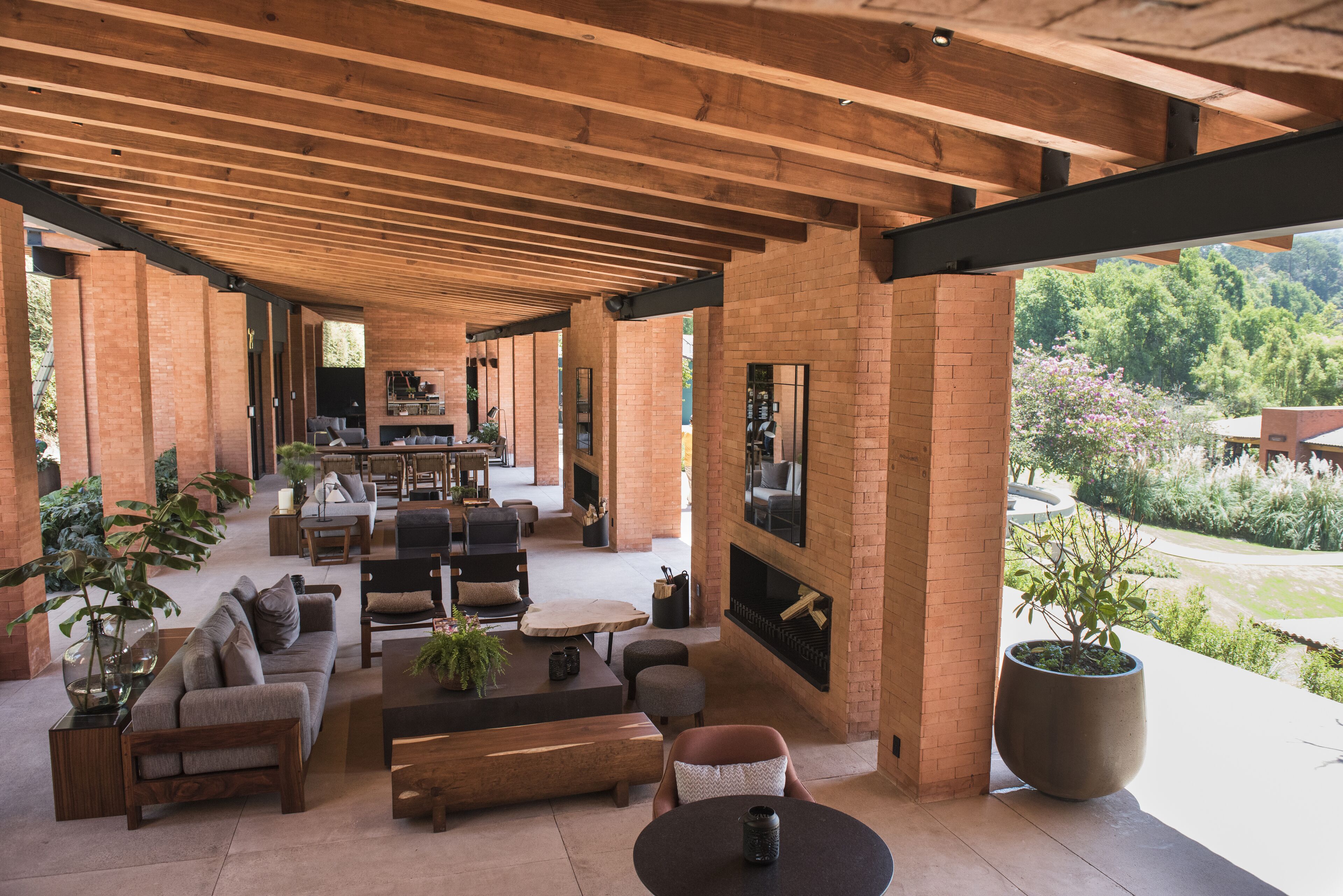 An open-plan living area with a fireplace, seating arrangements, and a view of the outdoors.