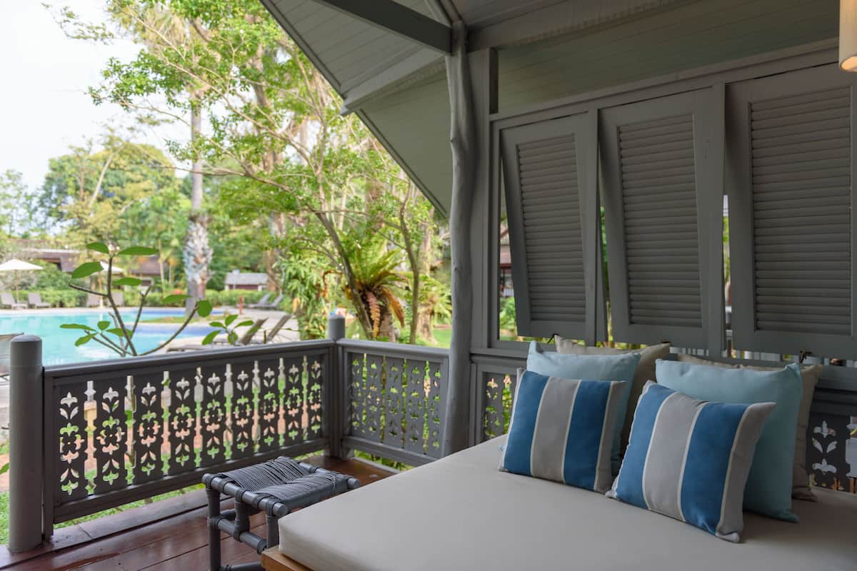 Ein Balkon mit Blick auf einen Pool und üppiges Grün.