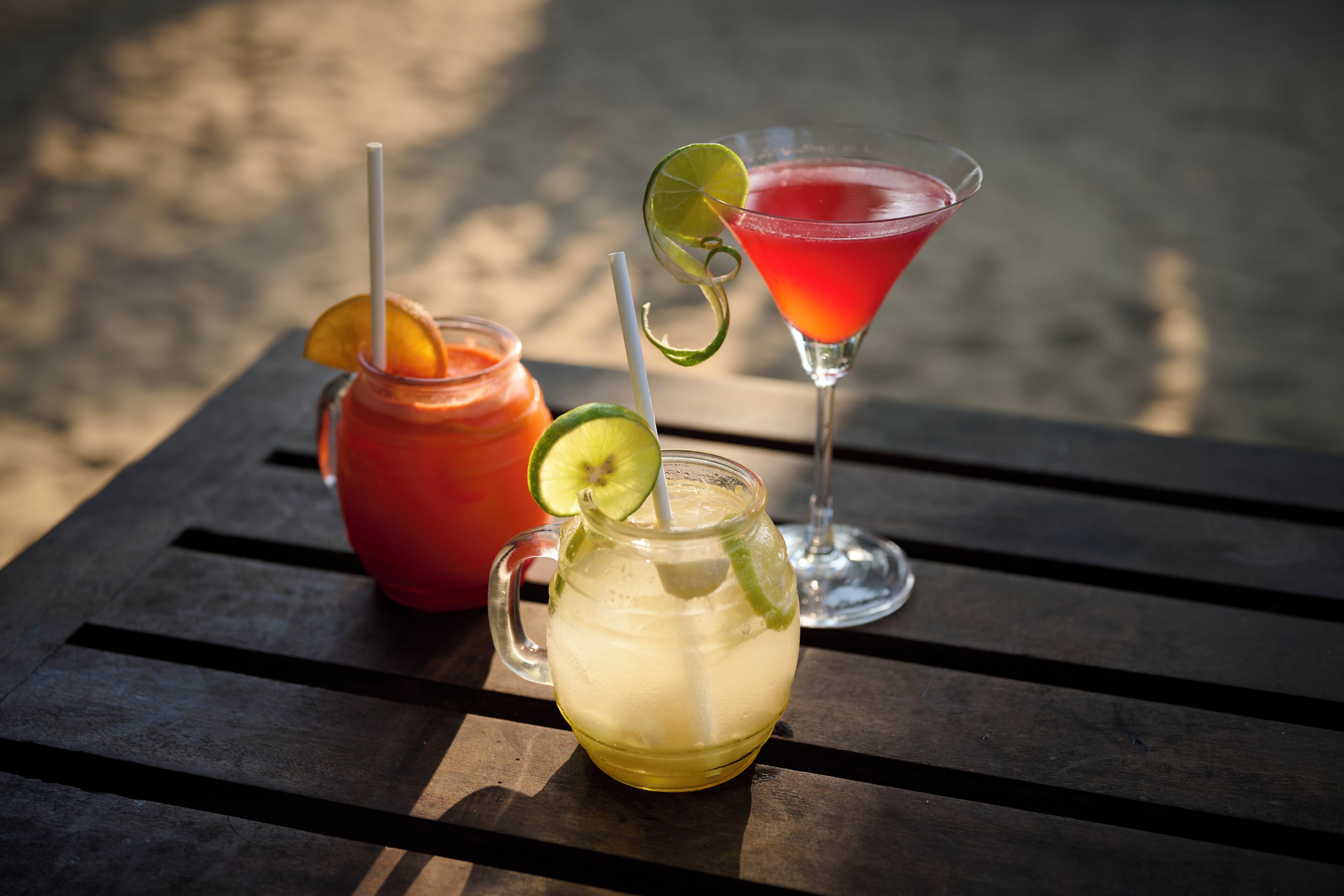 Three drinks on a wooden table.