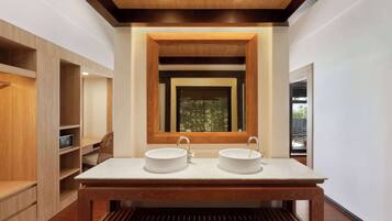 A modern bathroom with a wooden vanity, two sinks, and a large mirror.