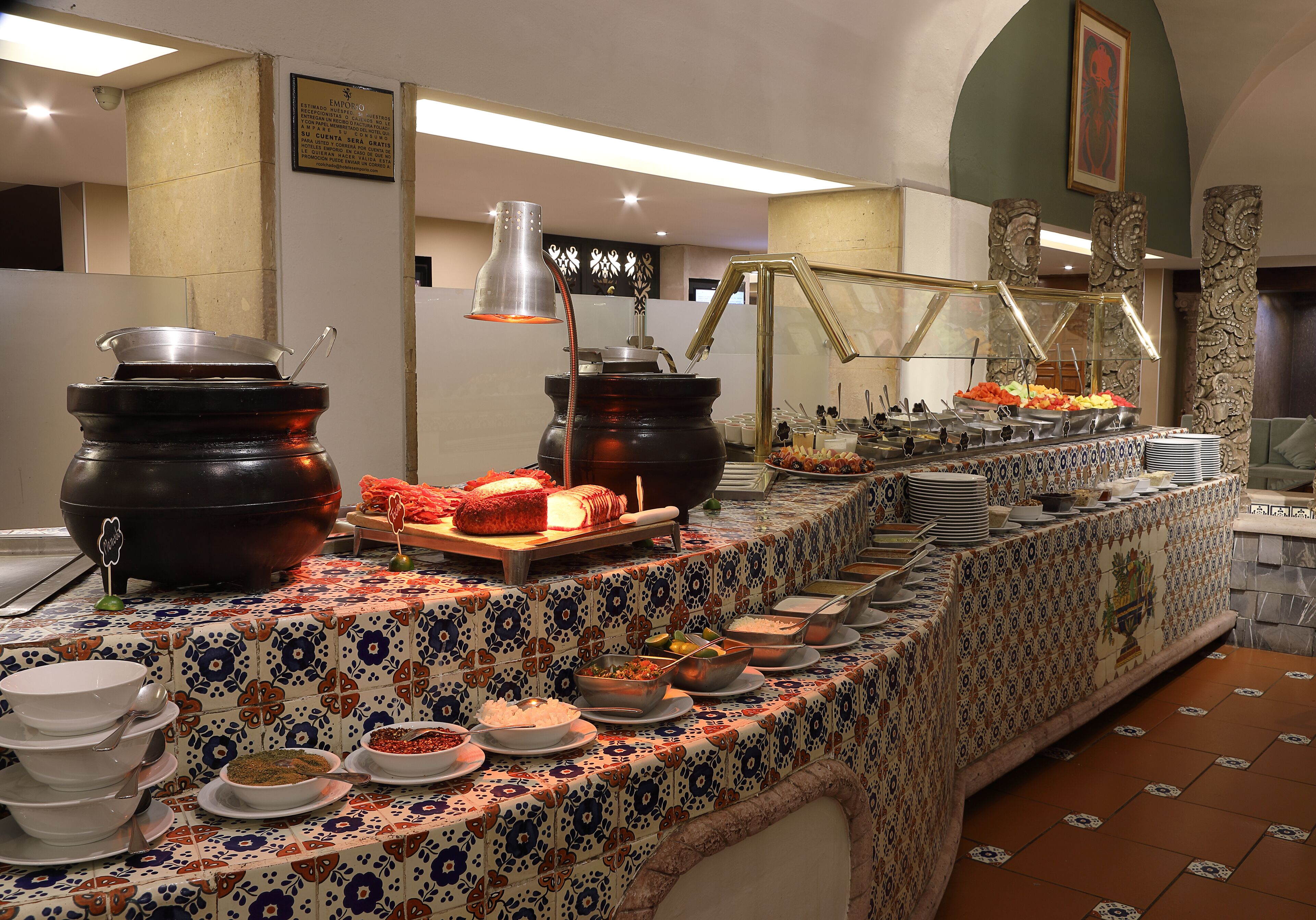 Una mesa de buffet con distintos alimentos y utensilios.