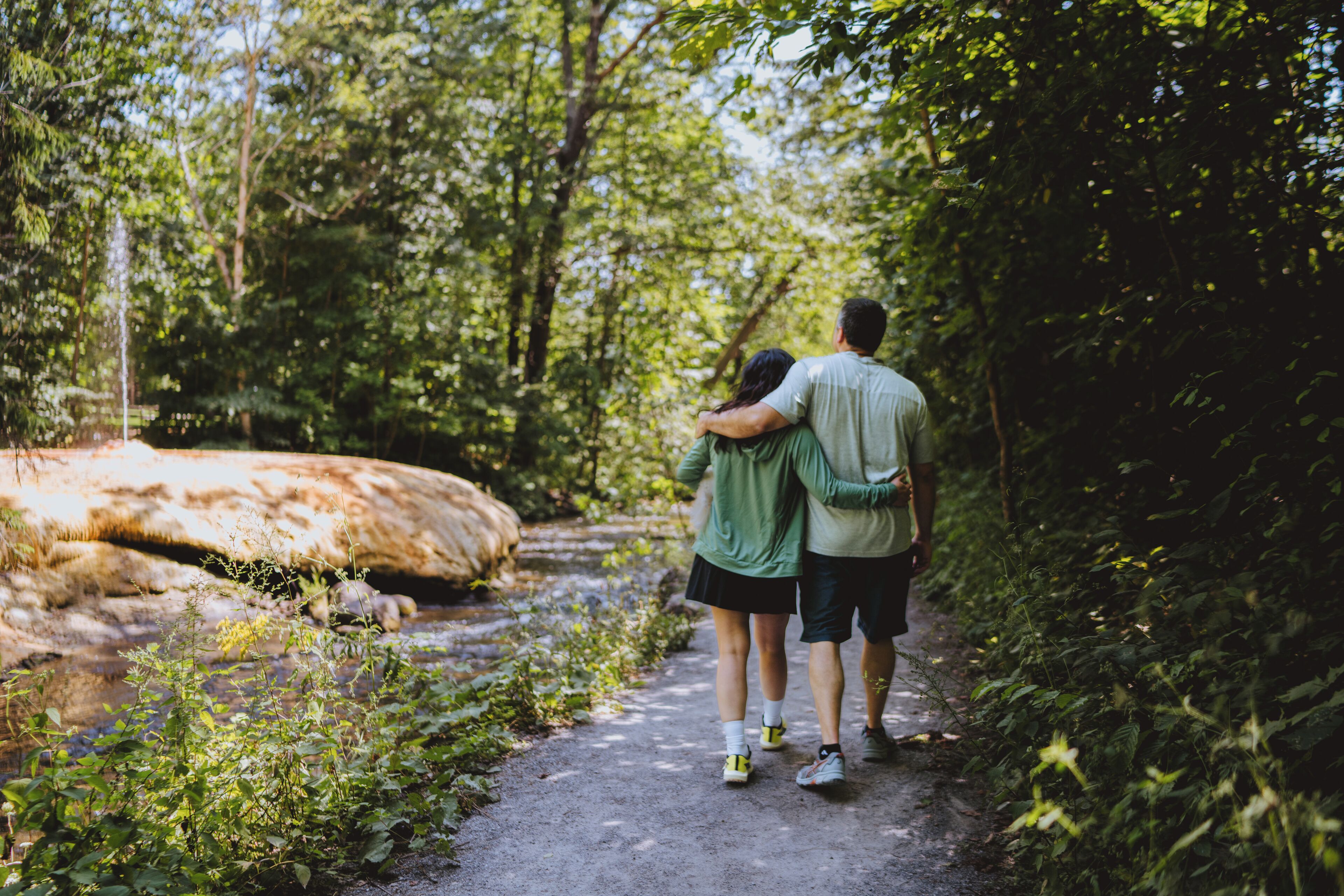 A couple walking on a forest path.