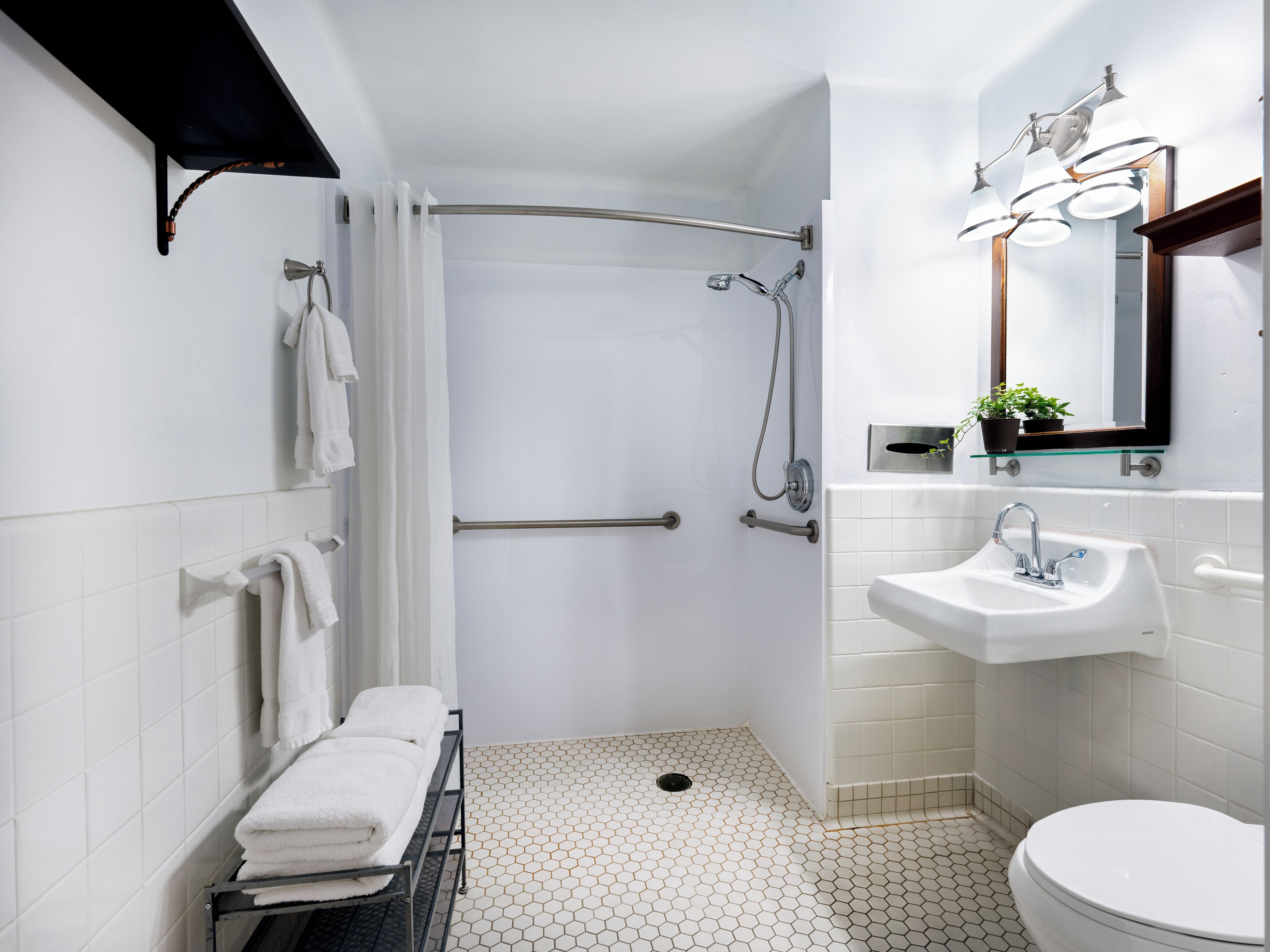 A modern bathroom with a shower, toilet, and sink.