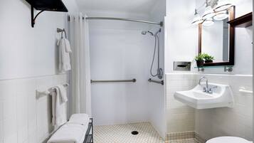 A modern bathroom with a shower, toilet, and sink.