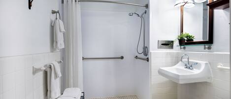 A modern bathroom with a shower, toilet, and sink.