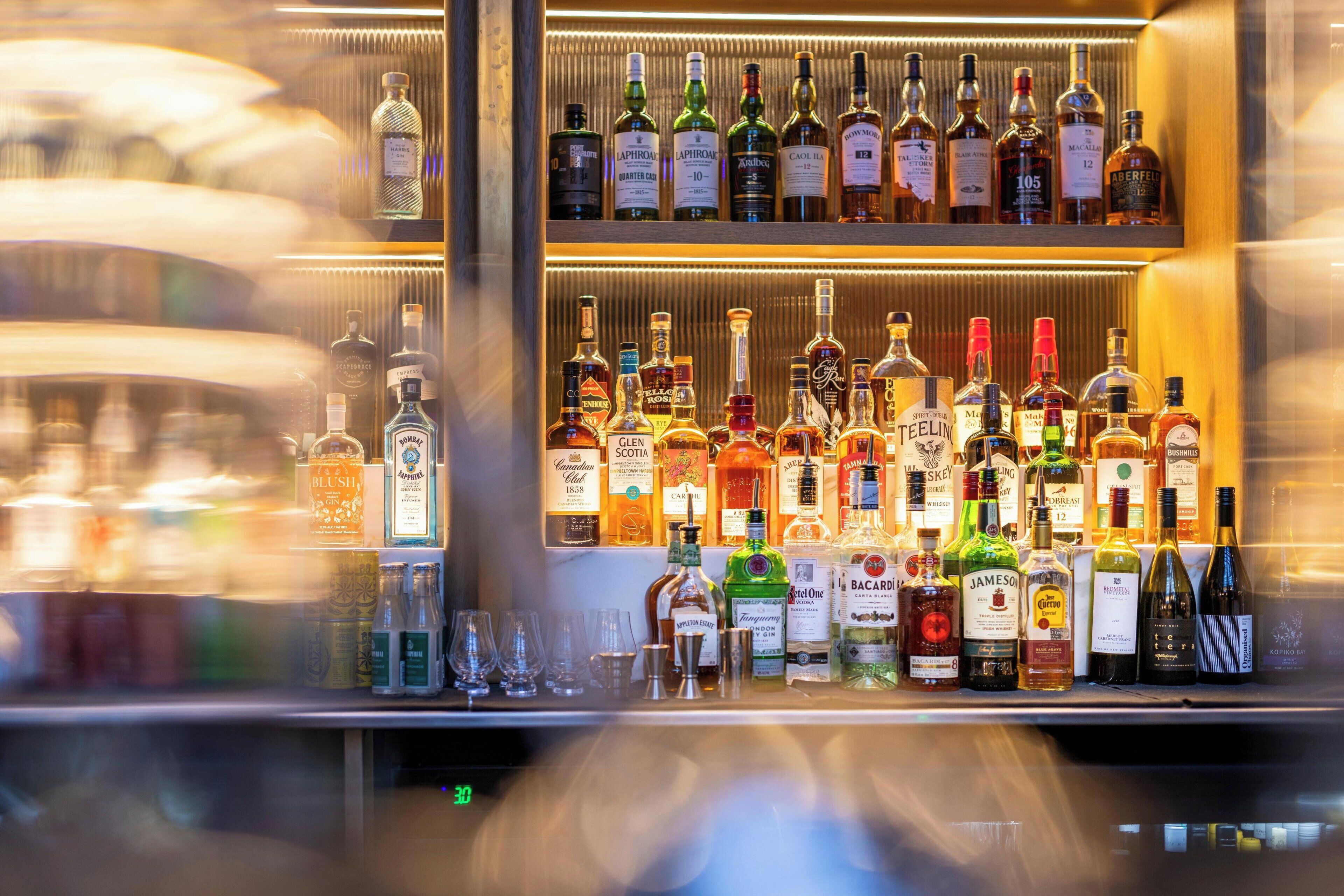 A bar with various bottles of alcohol and glasses.
