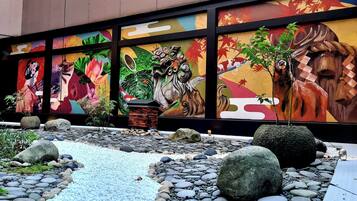 A mural with traditional Asian art, a koi pond, and a small tree.