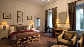 Una camera d'albergo con un letto, due lampade sui comodini, una scrivania, una sedia e un grande specchio.