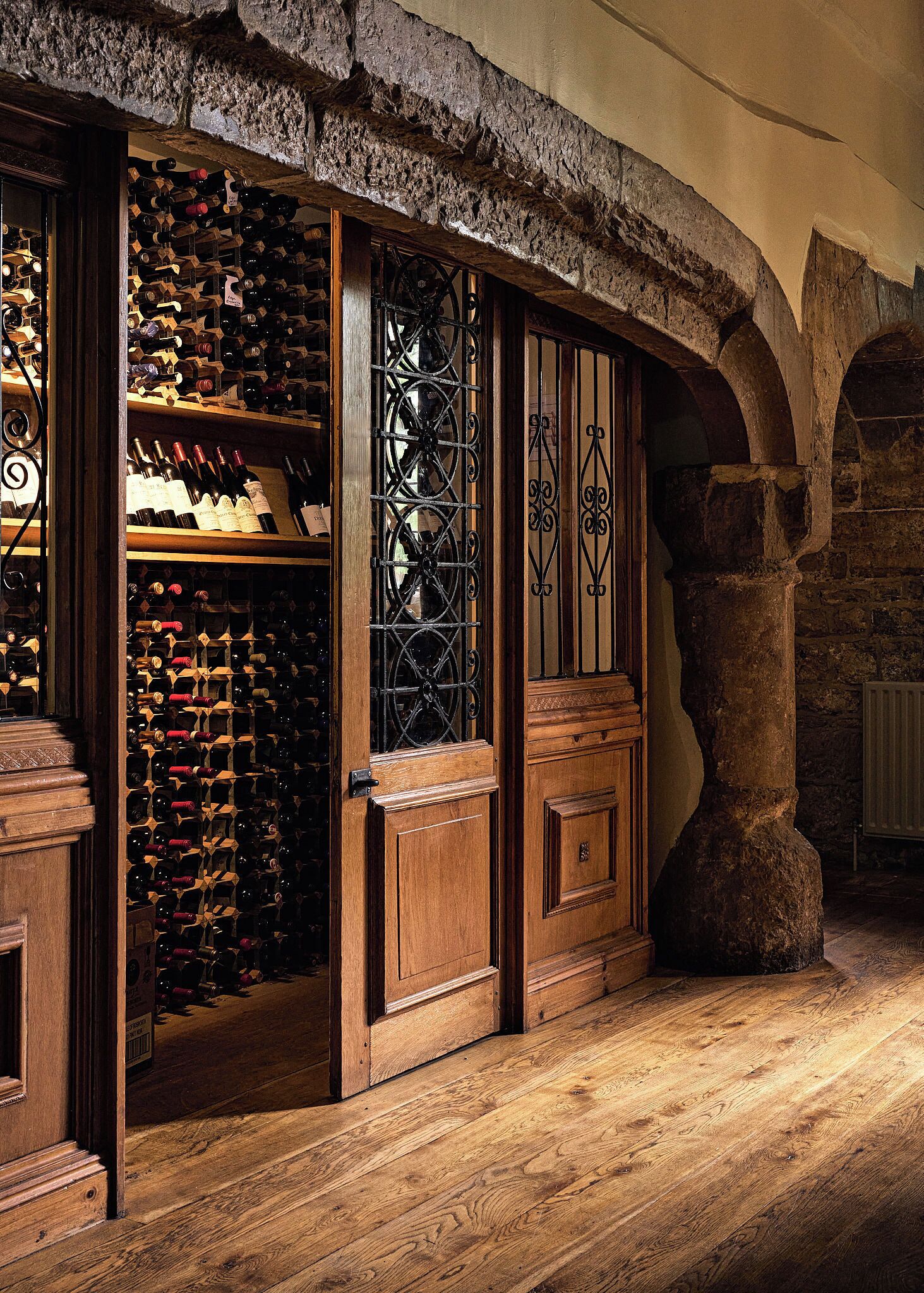 Una cantina vinicola con scaffali in legno e un'ampia bottiglia di vino.