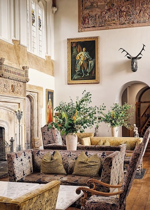 A grand room with a fireplace, ornate furniture, and a large painting. - Fawsley Hall (Daventry)