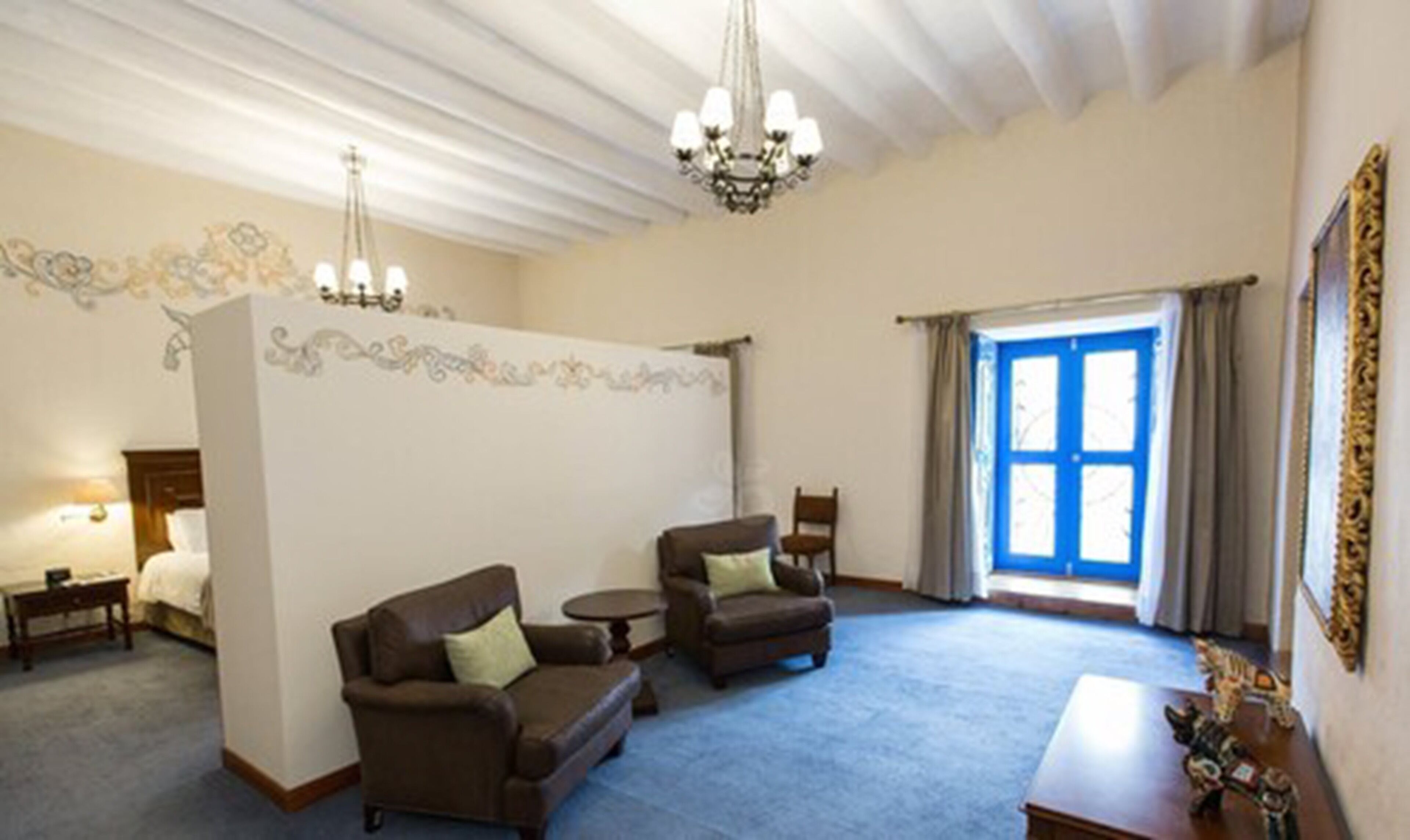 A spacious living room with two sofas, a small table, and a chandelier.