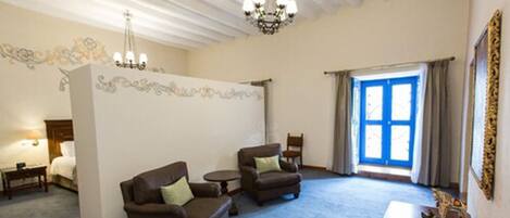 A spacious living room with two sofas, a small table, and a chandelier.