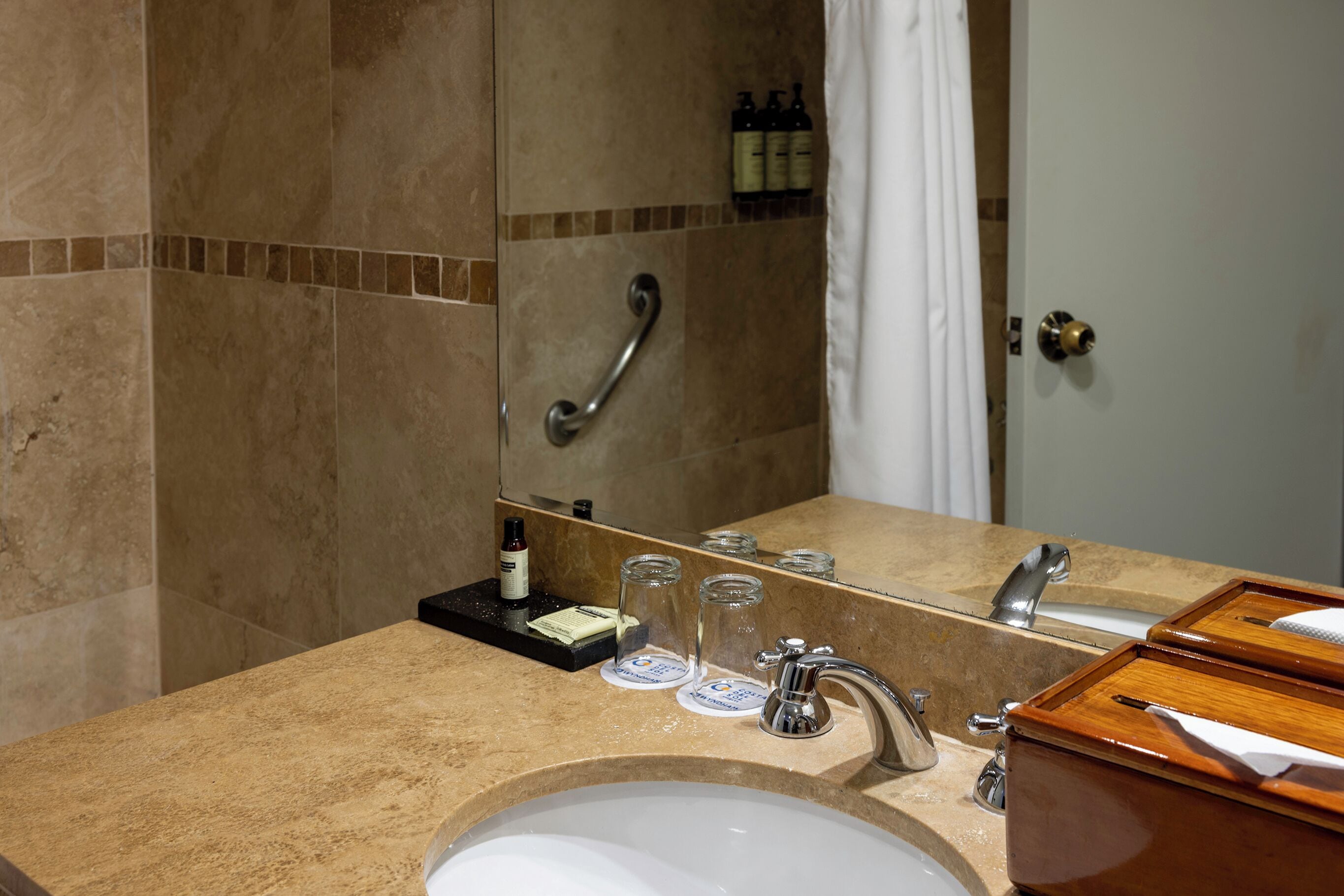 A bathroom with a sink, mirror, and toiletries.