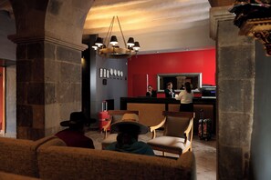 A lobby with a reception desk, a chandelier, and a red wall. - Wyndham Costa del Sol Cusco (Cusco)