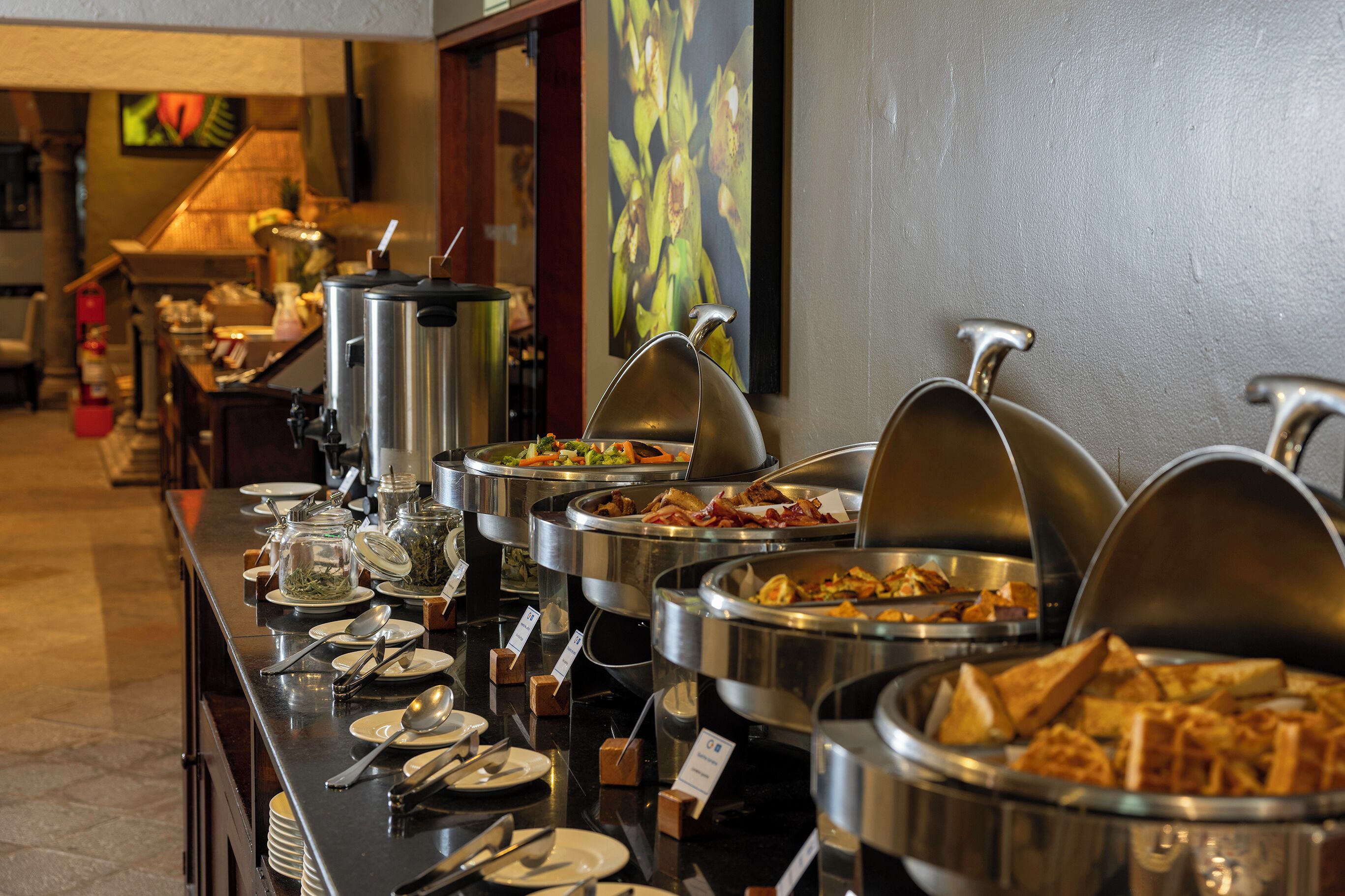 A buffet setup with various food items and utensils.