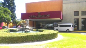 A building with a sign reading "CASA GRANDE" and a fountain in front.