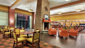 A spacious lobby with a fireplace, multiple seating areas, and a large window. - Hampton Inn & Suites Dallas-Mesquite (Mesquite)