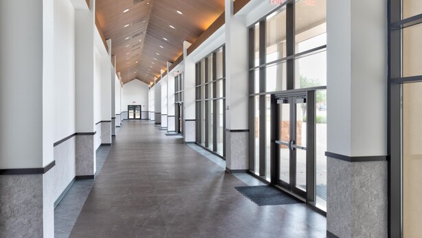 A long, narrow hallway with large windows and a ceiling with recessed lighting. - Hampton Inn & Suites Dallas-Mesquite (Mesquite)