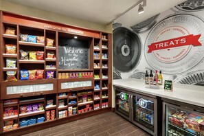Een kiosk met snacks en drankjes, waaronder chips, snoep en flessen.
