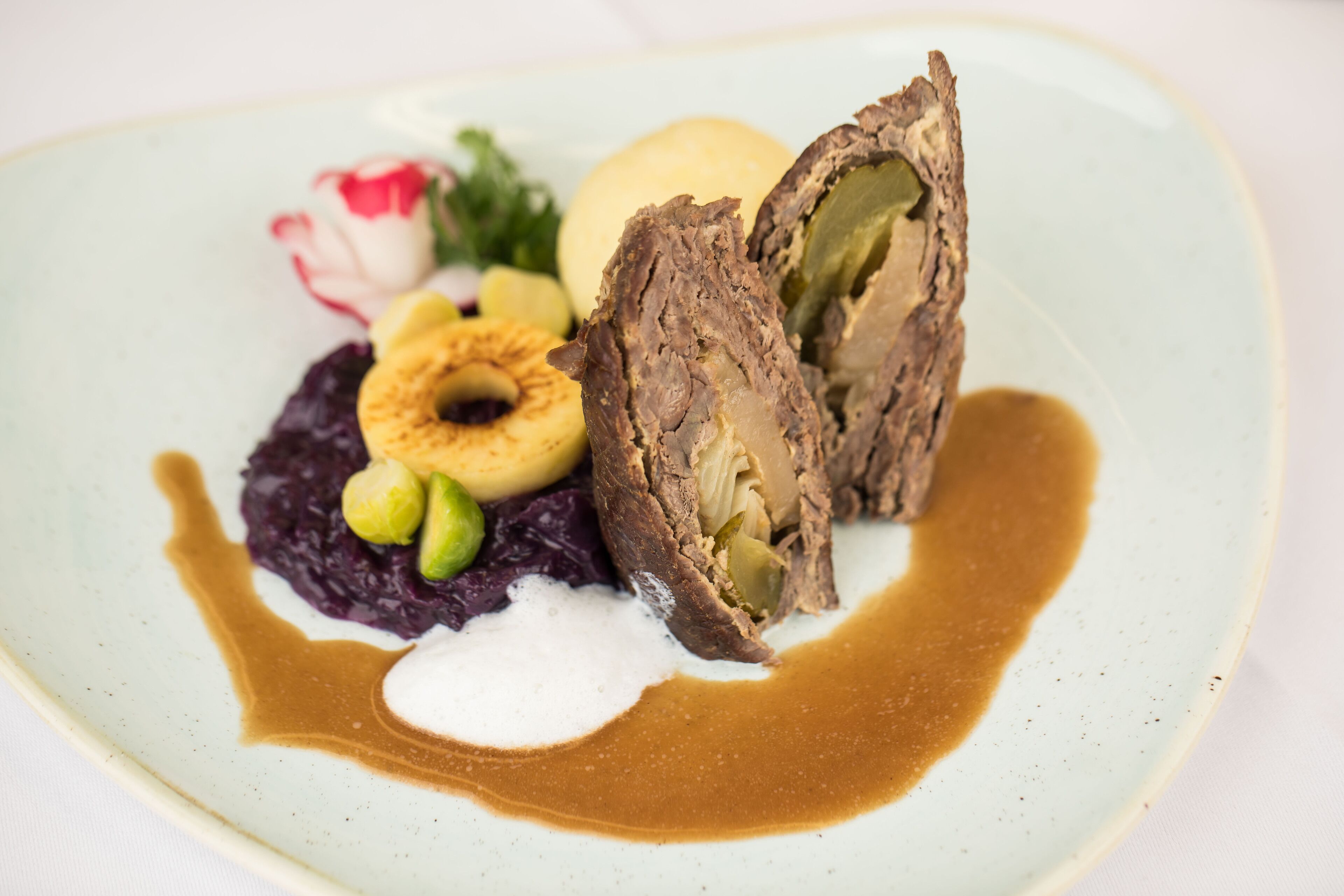 Ein Teller mit Speisen, darunter Fleisch, Gemüse und einer Soßenportion.