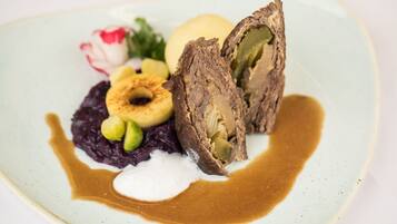 Ein Teller mit Speisen, darunter Fleisch, Gemüse und einer Soßenportion.