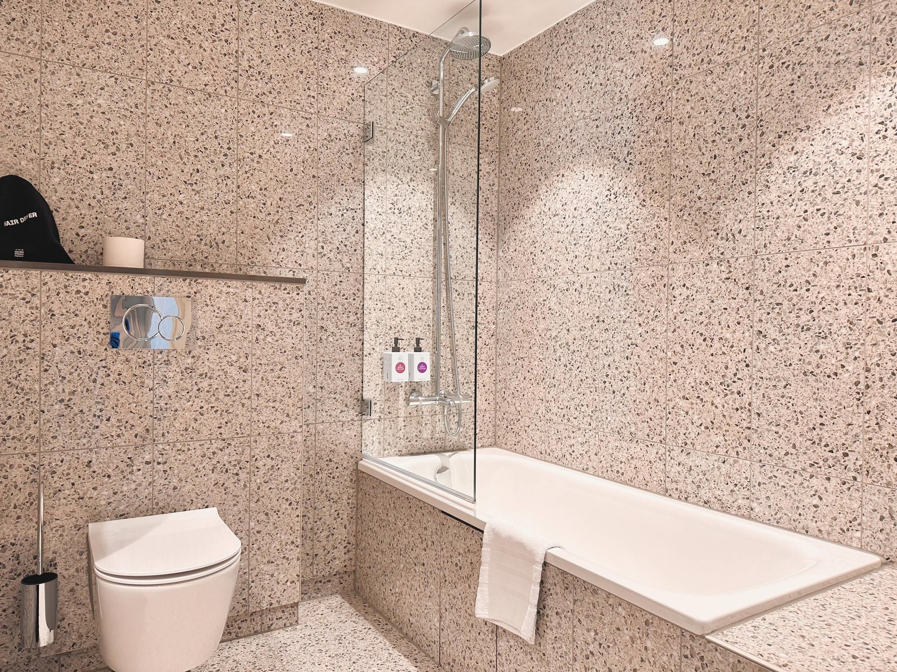Un bagno moderno con doccia, WC e vasca da bagno.