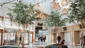 A spacious lobby with modern lighting, seating areas, and indoor plants. - Quality Hotel Arlanda XPO (Arlandastad)