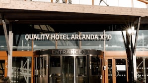 The entrance to Quality Hotel Arlanda Xpo with a modern design, featuring a glass facade and a wooden overhang. - Quality Hotel Arlanda XPO (Arlandastad)