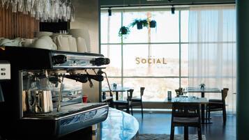 A coffee machine in a cafe with a large window and the word "SOCIAL" on it.