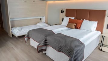 A double bed with a brown headboard, a bedside table, and a built-in wardrobe.