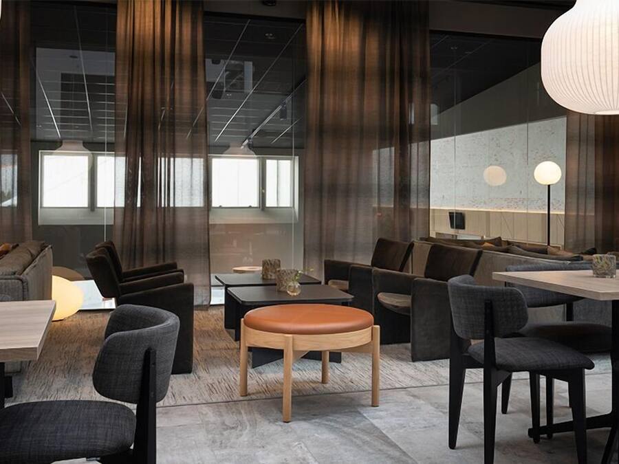 A modern interior with a seating area, tables, and a large window.