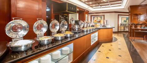 A buffet setup with various food items and utensils.