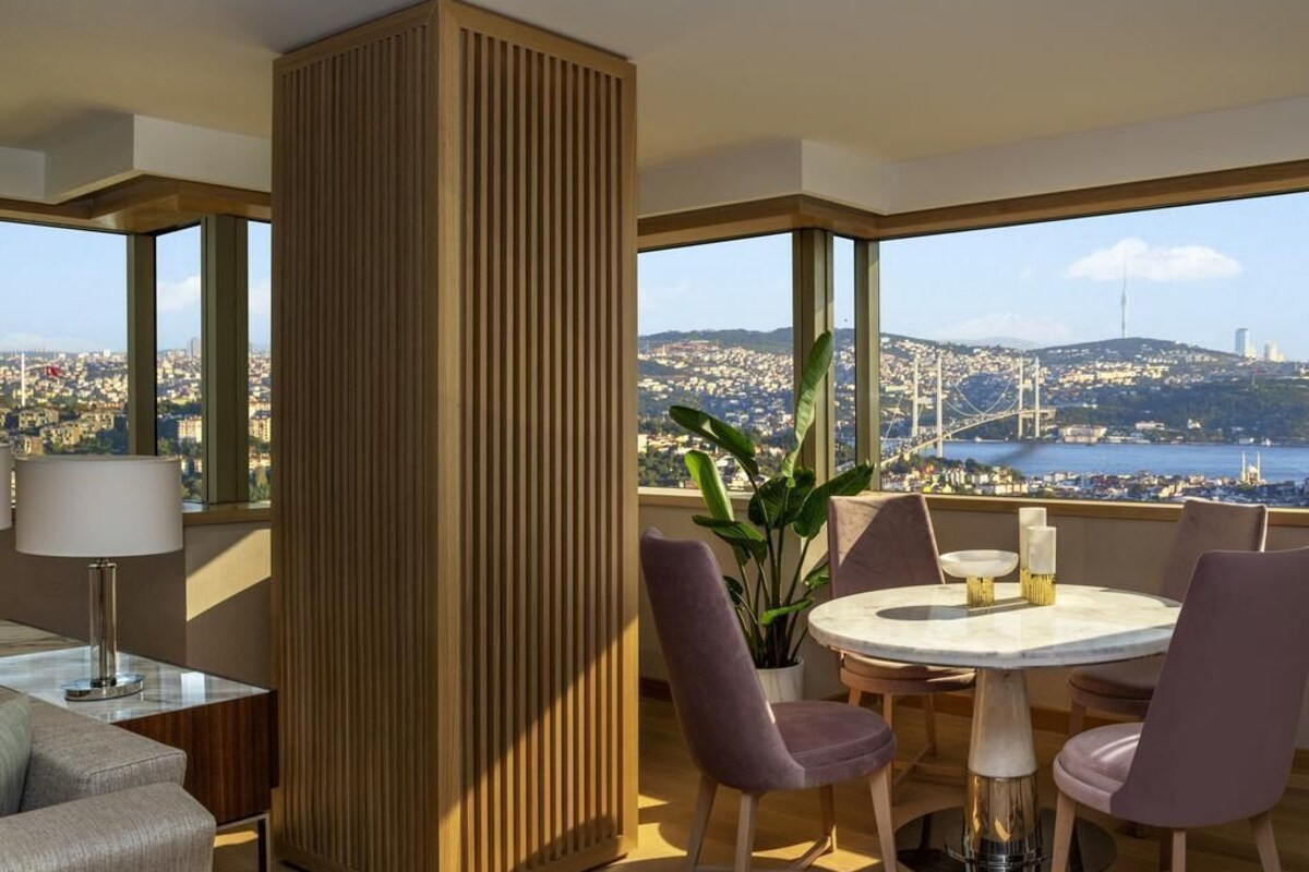A modern room with a large window, a round table, and purple chairs.