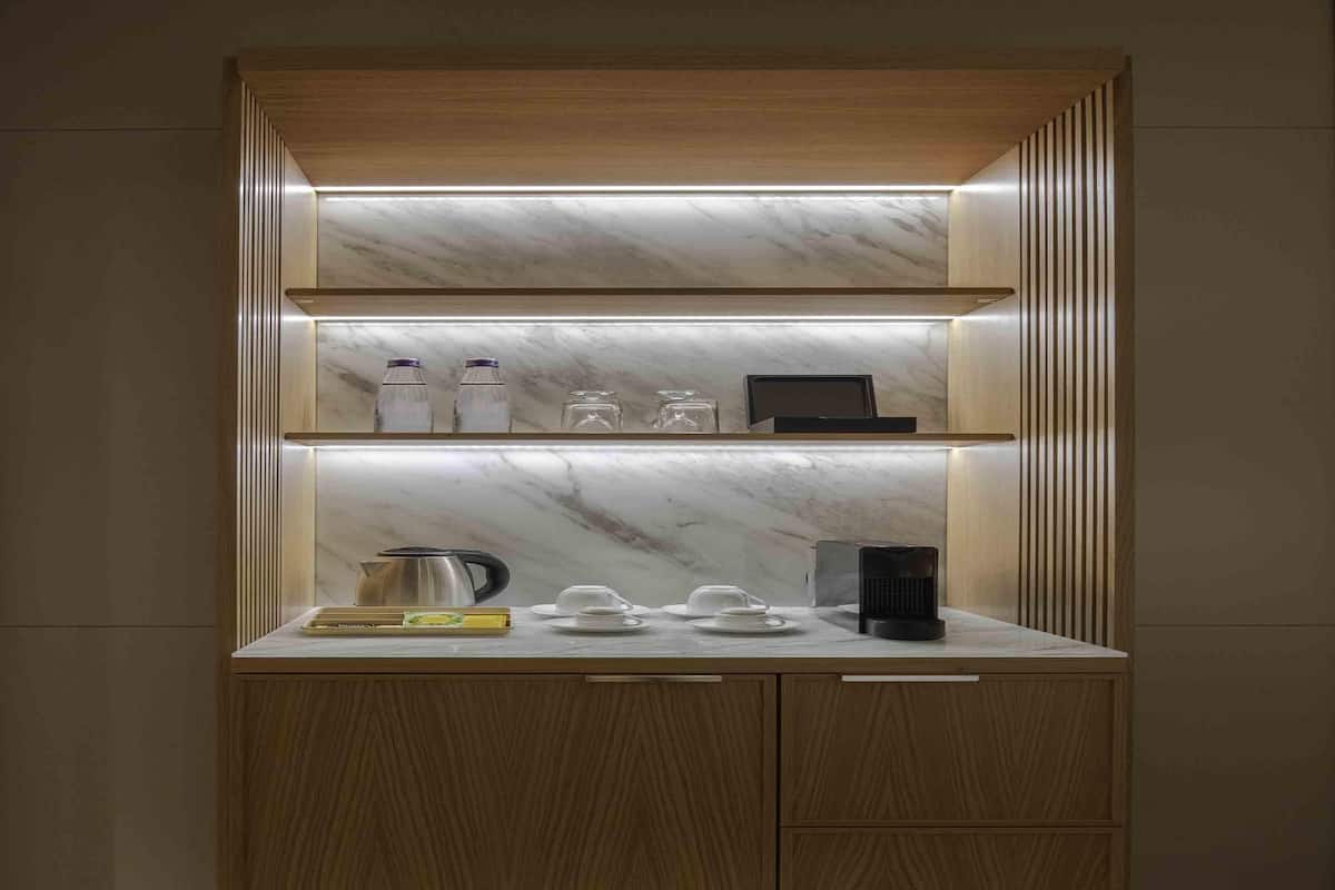 A modern kitchen with a marble countertop, wooden cabinets, and built-in shelves.