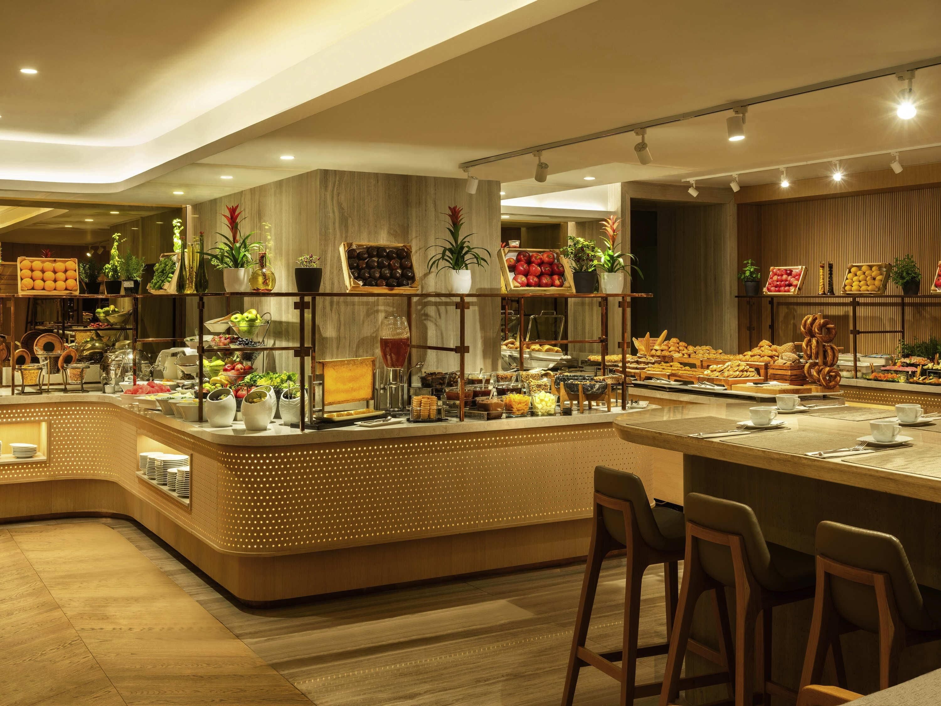 A buffet area with various food items and plants.