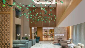 A modern lobby with a seating area, a decorative ceiling light, and a sign reading 'Hünkär 1950'. - Mövenpick Hotel Istanbul Bosphorus (Istanbul)