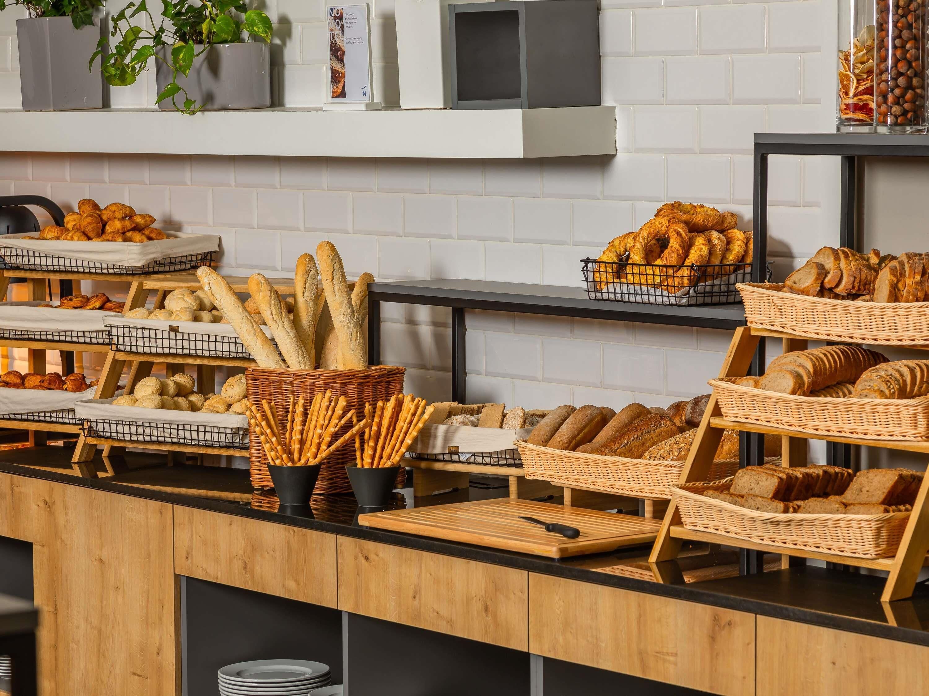 Mostrador de panadería con panes y pasteles exhibidos en cestas.