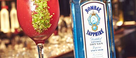 A bottle of Bombay Sapphire gin and a cocktail glass with a garnish.