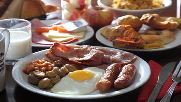 Prato de café da manhã com ovos, salsichas, feijão e bacon.