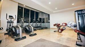 A modern gym with various cardio and strength training equipment, large windows, and a clean, polished floor. - Hotel Del Prado (Mexico City)
