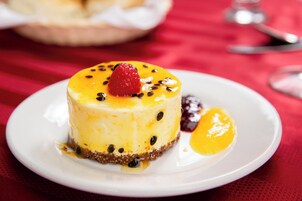 Un postre sobre un plato blanco con mantel rojo.