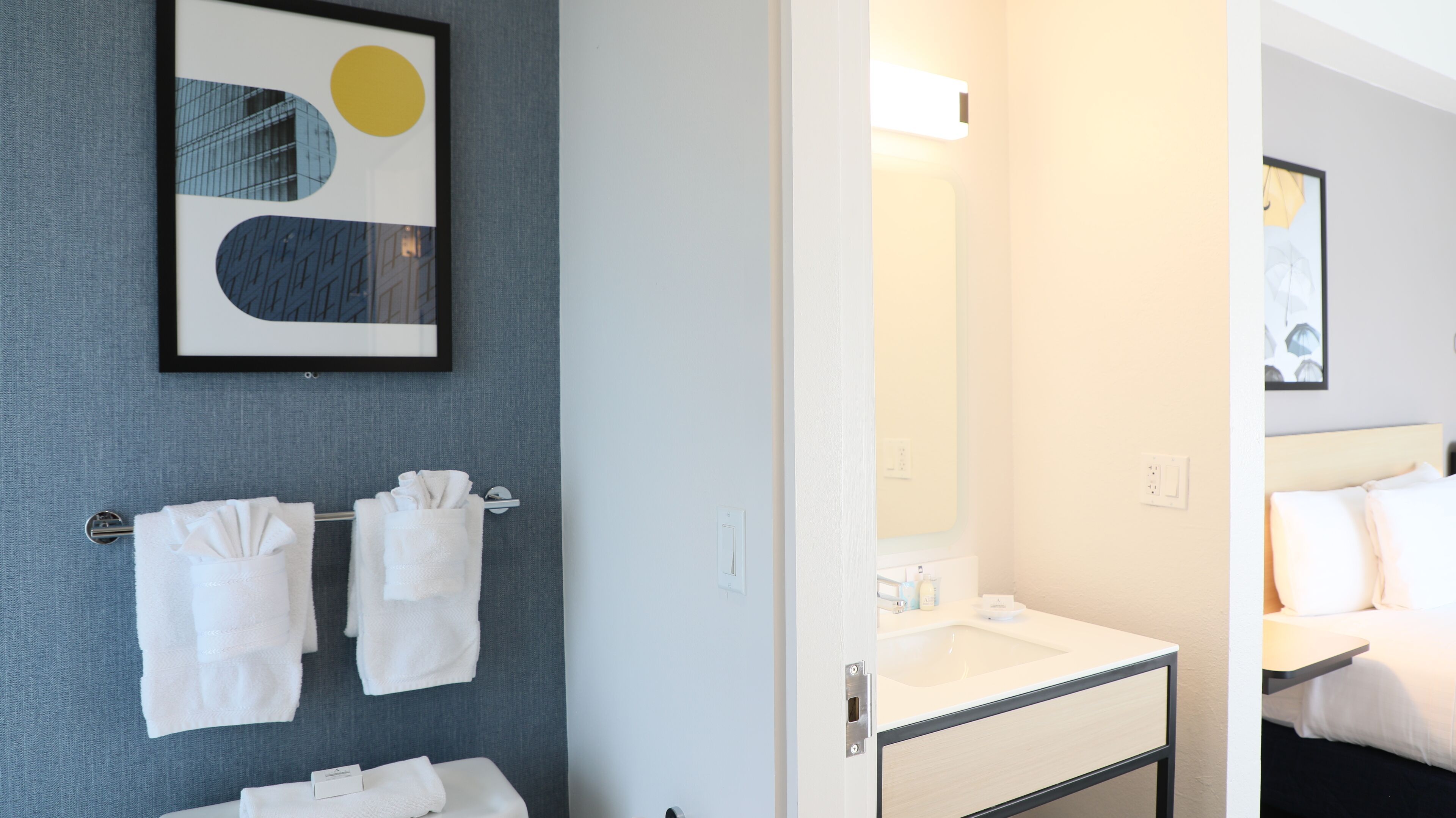 Ein Hotelzimmer mit Bad, einem Bett und einem Handtuchhalter an der Wand.
